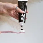 Dabīga zobu pasta balinoša ar aktivētu kokogli, melnā krāsā uzlikta uz zobu birstes